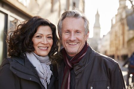 Portrait Of Mature Couple Walking Through City In Fall Together