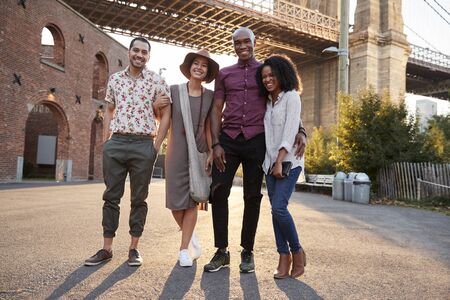 Portrait Of Friends Walking By Brooklyn Bridge In New York Cityの写真素材