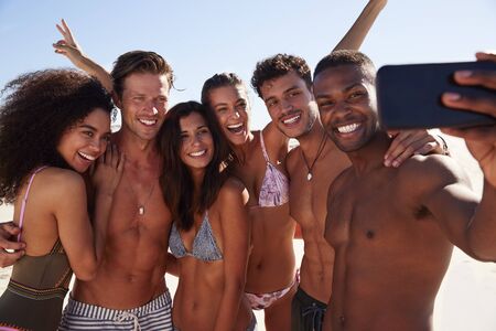 Group Of Friends Posing For Selfie Together On Beach Vacationの写真素材