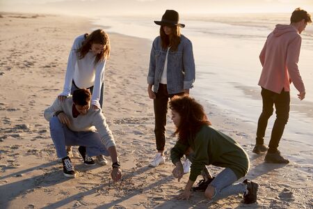 Friends Playing Noughts And Crosses In Sand On Winter Beachの写真素材