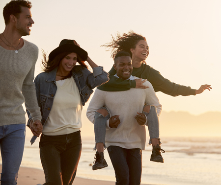 Group Of Friends Having Fun Running Along Winter Beach Togetherの写真素材