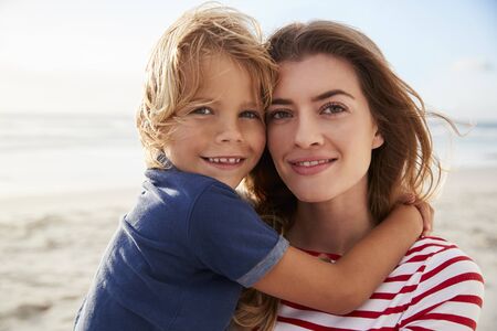 Portrait Of Mother Hugging Son On Summer Beach Vacation