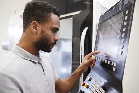 Male Engineer Operating CNC Machinery In Factory