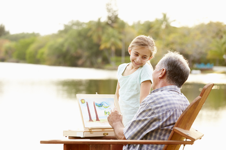 Grandfather With Granddaughter Outdoors Painting Landscapeの写真素材