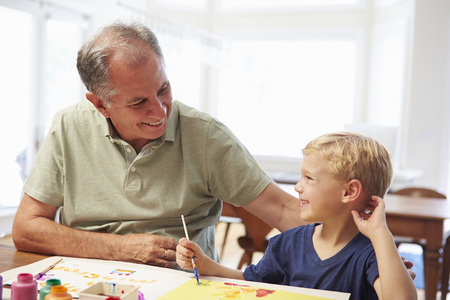 Grandfather Painting Picture With Grandson At Homeの写真素材