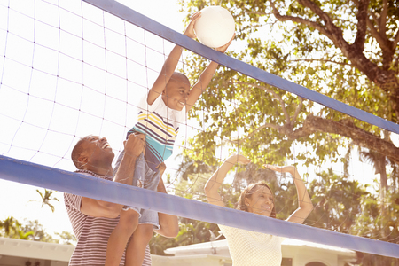 Family Playing Game Of Volleyball In Gardenの写真素材