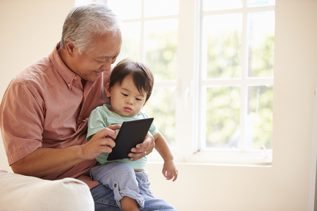Grandfather And Grandson Using Digital Tablet Togetherの写真素材