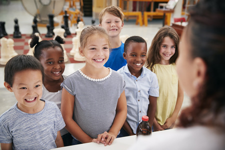 Group of smiling kids listening to teacher in science centreの写真素材