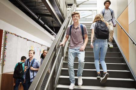 High School Students Walking Down Stairs In Busy College Buildingの写真素材