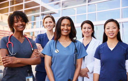Female healthcare colleagues standing outside hospitalの写真素材