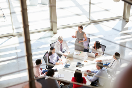 Female manager addressing a meeting, seen from stairsの写真素材