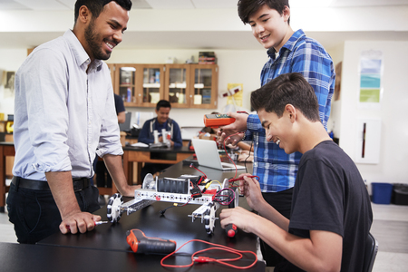 Teacher With Male Pupils Building Robotic Vehicle In Science Lessonの写真素材