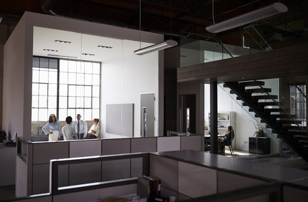 Business people working in office units seen from corridor