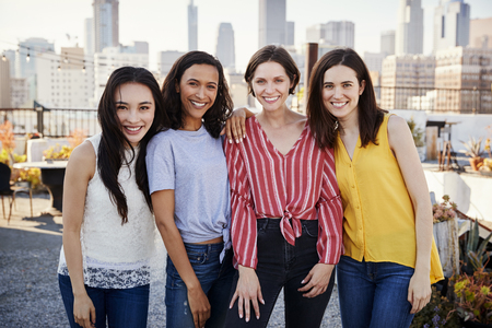 Portrait Of Female Friends Gathered On Rooftop Terrace For Party With City Skyline In Backgroundの写真素材