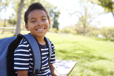 Young mixed race schoolboy with backpack smiles to cameraの写真素材