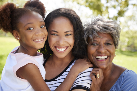 Portrait Of Grandmother With Adult Daughter And Granddaughter Relaxing In Parkの写真素材
