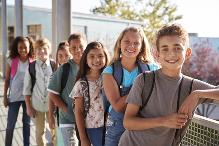 Elementary school kids with backpacks smiling to the cameraの写真素材