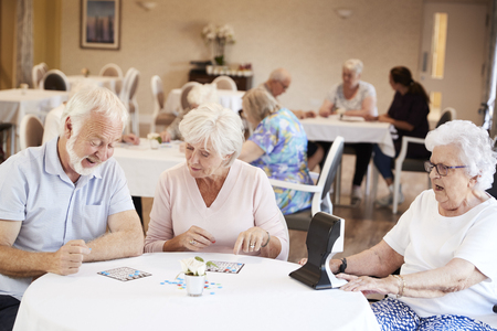Group Of Seniors Playing Game Of Bingo In Retirement Homeの写真素材