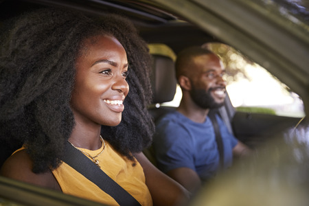 Young black couple smiling in a car during a road tripの写真素材