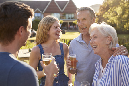 Parents With Adult Offspring Enjoying Outdoor Summer Drink At Pubの写真素材
