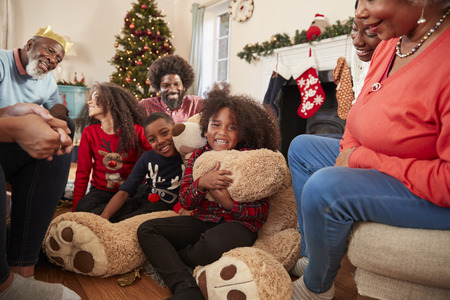Children Playing With Giant Teddy Bear As Multi-Generation Family Open Gifts On Christmas Dayの写真素材