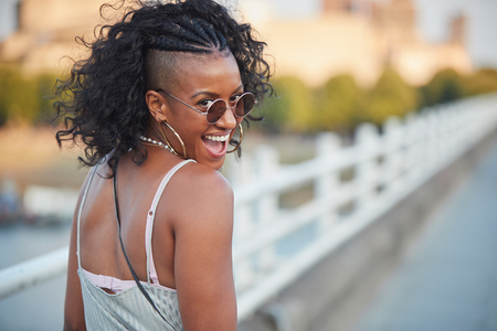 Trendy woman in striped camisole and sunglasses, turningの写真素材