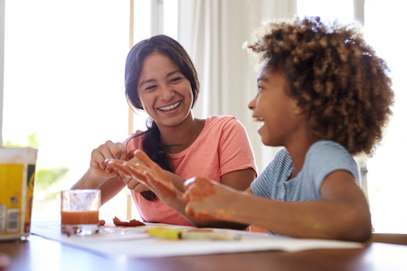 Close up of two girlfriends having fun playing with modelling clay at home, close up, selective focusの写真素材