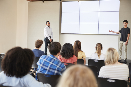 Male Student Giving Presentation To High School Class In Front Of Screenの写真素材