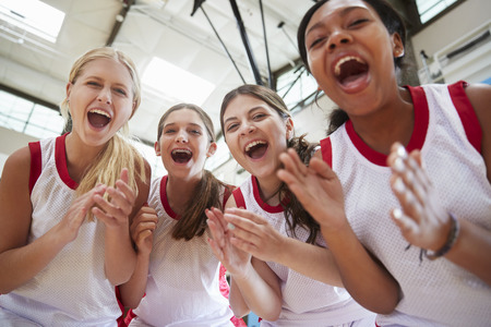 Portrait Of Female High School Basketball Team Celebrating On Courtの写真素材