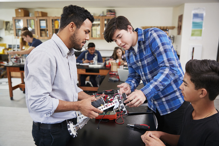 Teacher With Male Pupils Building Robotic Vehicle In Science Lessonの写真素材