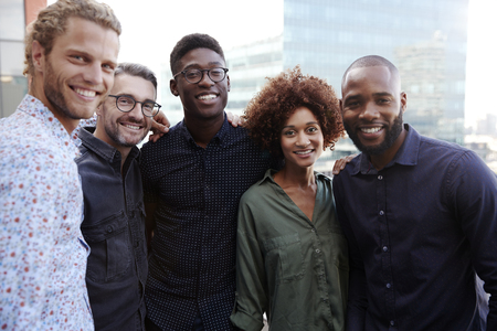 Happy creative business colleagues smiling to camera outdoors, waist up, close upの写真素材
