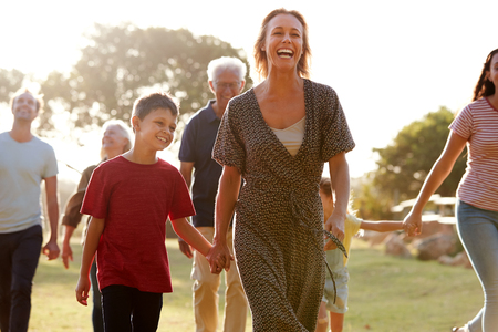 Multi-Generation Family Walking In Countryside Against Flaring Sunの写真素材