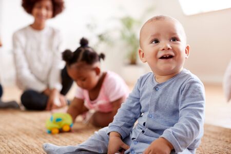Two Mothers Meeting For Play Date With Babies At Home In Loft Apartmentの写真素材