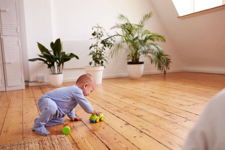 Baby Boy Playing With Toys On Floor At Homeの写真素材