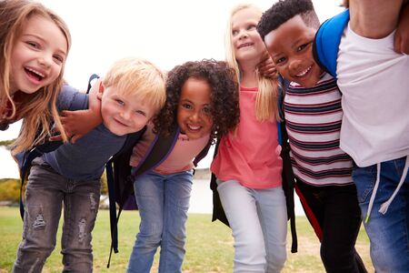 Portrait Of Excited Elementary School Pupils On Playing Field At Break Timeの写真素材