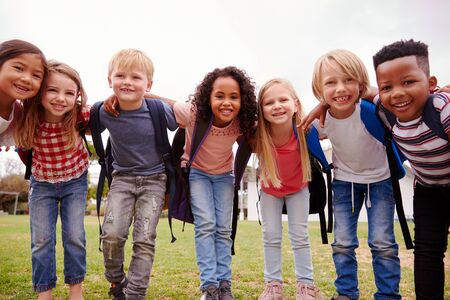 Portrait Of Excited Elementary School Pupils On Playing Field At Break Timeの写真素材