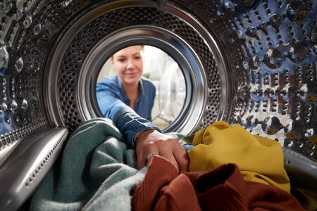 View Looking Out From Inside Washing Machine As Young Woman Does Laundryの写真素材