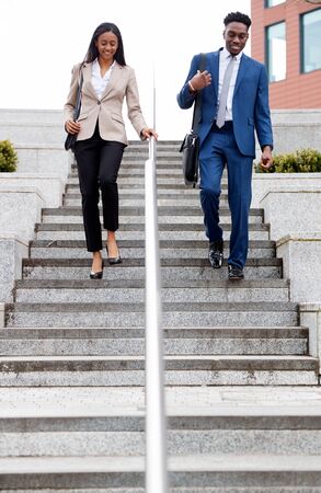 Businessman And Businesswoman Commuting To Work Walking Down Steps Outside Office Buildingの写真素材