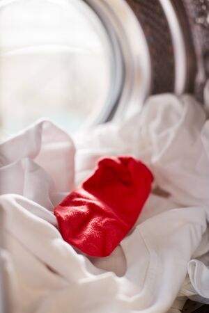 View Looking Out From Inside Washing Machine With Red Sock Mixed With White Laundryの写真素材