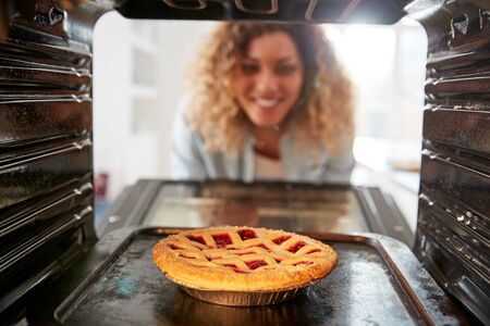 View Looking Out From Inside Oven As Woman Cooks Fruit Tartの写真素材