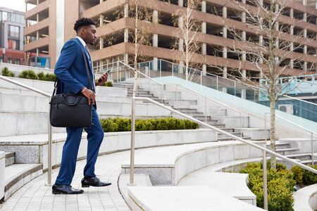 Businessman Commuting To Work Walking Down Steps To Railway Stationの写真素材