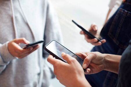 Close Up Of Businesswomen Using Mobile Phones In Modern Officeの写真素材