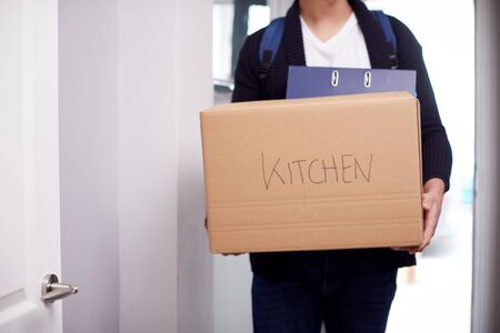 Close Up Of Male College Student Carrying Box Labeled Kitchen Moving Into Accommodationの写真素材