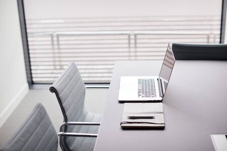 Laptop And Notebook On Table In Empty Meeting Room Of Modern Officeの写真素材