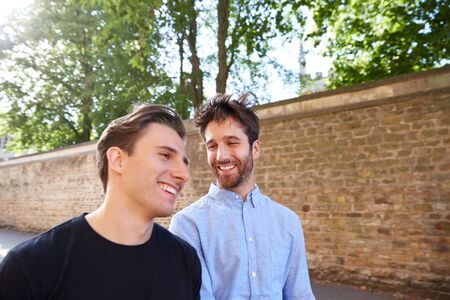 Loving Male Gay Couple On Vacation Walking Along City Streetの写真素材