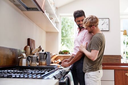 Male Gay Couple At Home In Kitchen Making Breakfast Togetherの写真素材