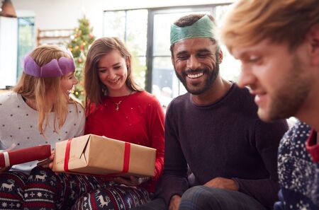 Gay Friends At Home Exchanging Gifts On Christmas Day Togetherの写真素材