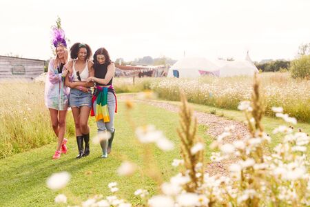 Female Friends Walking Back To Tent After Outdoor Music Festivalの写真素材
