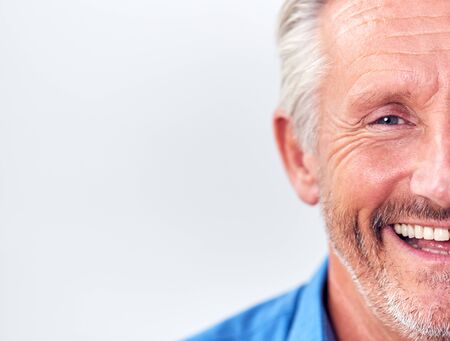 Cropped Studio Shot Of Mature Man Against White Background Laughing At Cameraの写真素材