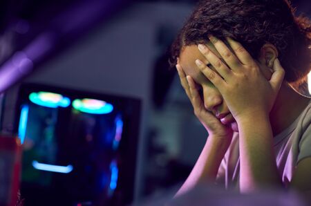 Stressed Teenage Girl Being Bullied Online Whilst Gaming At Home